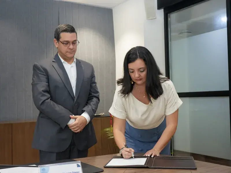 Ana Marcela Uribe Figueroa, directora de la Maestría en Psicología de la Salud realizando la firma del acta de su posesión, a su izquierda Pablo Rubén Vernaza Gómez, secretario general de la Seccional. 